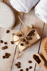 Concept of home natural organic skin care. Handmade soap bars with coffee used as gentle scrub. Brush to increase anti-cellulite effect. Relax pleasant treatement. Wooden background close up