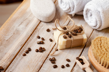 Naklejka premium Concept of home natural organic body care. Handmade soap bars with coffee used as gentle scrub. Brush to increase anti-cellulite effect. Relax, pleasant treatement. Close up macro, wooden background