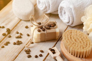 Fototapeta na wymiar Concept of home natural organic skin care. Handmade soap bars with coffee used as gentle scrub. Brush to increase anti-cellulite effect. Relax pleasant treatement. Wooden background close up