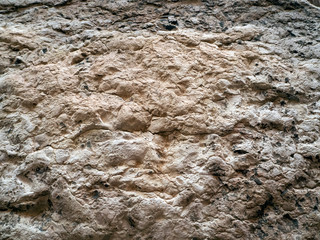 The texture of the old natural stone. The surface of the stone is uneven and cracked. Natural stone background.
