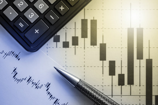 calculator, pen and graph - concept of financial data analysis, stock trading, growth and fall of stock indices and markets