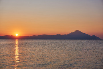Naklejka na ściany i meble Wonderful sunrise view behind the mountains and next to the sea