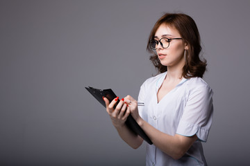 Attractive american doctor holding a black tablet with medical records of her patients