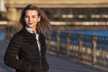 Beautiful Young Woman Standing On Embankment at Sunny Day.