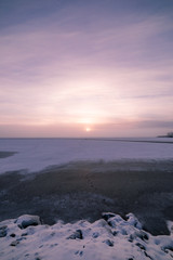 Sun through fog at lake winter morning