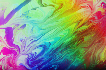Fototapeta na wymiar Marble background toned in rainbow colors.Beautiful stains of liquid nail polish,fluid art technique.Pour painting art work.Modern backdrop.Good for placing text or design.Cosmetics concept.