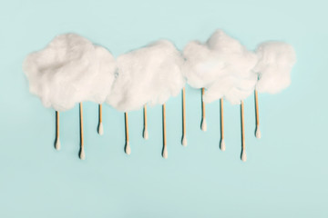 Rain drops from wooden ear sticks.Natural cotton buds for eye cleaning.Fluffy cotton clouds.The concept of environmental problems and non plastic products.Solving pollution by plastick waste.