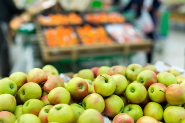 Green and red apples on boxes in supermarket