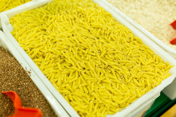 Macaroni, pasta in boxes on the counter in the supermarket. buying cereals in the store. food background