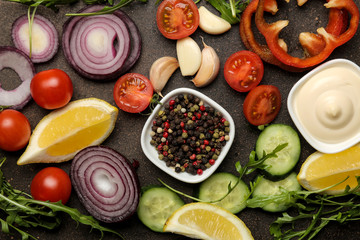 Set of sliced vegetables and spices for the preparation of salads or other dishes on a dark table. top view. ingredients for cooking.
