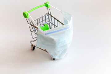 Empty shopping trolley with medical face mask. Empty shops,crisis,quarantine and  virus prevention...