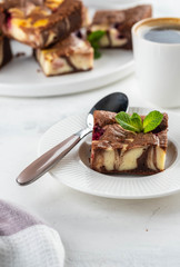 Cheesecake brownies with raspberry stacked on a white plate.