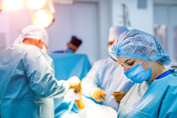 Team of surgeons operating in the hospital. Modern equipment in operating room. Medical devices for...