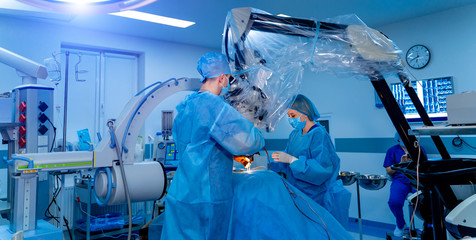 Team surgeon at work in operating room. Modern equipment in clinic. Operating room with X-ray medical scan