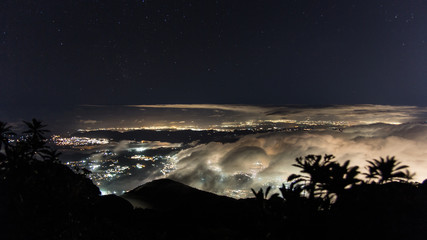 Panoramic view of Caracas at night under the clouds from El Avila National Park