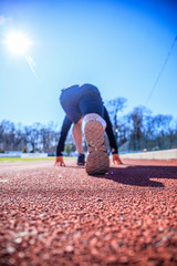 Feet on starting block ready for a spring start. Focus on leg of a athlete about to start a race in...
