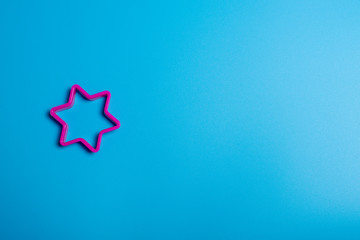 Pick plastic cookie cutter for making cookies in the shape of a star on a blue background. Culinary...