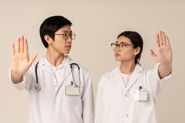 Image of asian young medical doctors doing stop gesture during disease