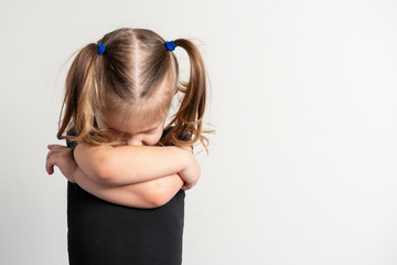 portret emotional 4 year old girl with two ponytails. the baby is offended and angry, arms crossed on her chest, head down © Елена Гурова