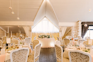 Wedding decor in the restaurant. Beautiful bright podium decorated with flowers.