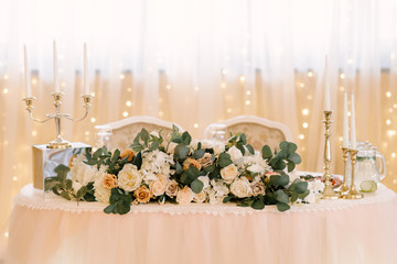 Wedding decor in the restaurant. Beautiful bright podium decorated with flowers.
