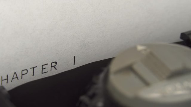 Typing CHAPTER 1 in black ink on an old mechanical typewriter.