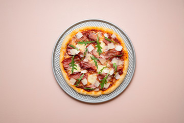 Pizza prosciutto on a baking tray. Whole ham pizza with arugula