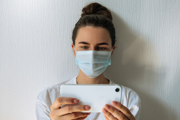 woman wearing face medical protective mask using her phone inside on carnitine because of virus epidemic on white background