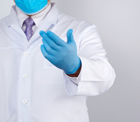 doctor in a white coat with buttons and blue latex gloves holds out his hand forward, concept of invitation