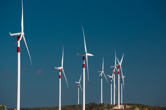 Panorama of a big wind farm on green meadow in front of blue sky