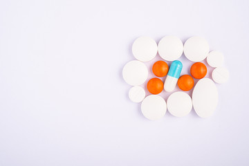 Pills and tablets on bright white background, healthcare medical concept, antibiotics and cure, top view copy space