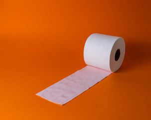 View of a white toilet paper roll over an orange background
