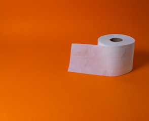 View of a white toilet paper roll over an orange background