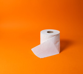 View of a white toilet paper roll over an orange background