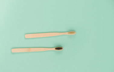 Two bamboo brushes for brushing teeth, light dark pile.