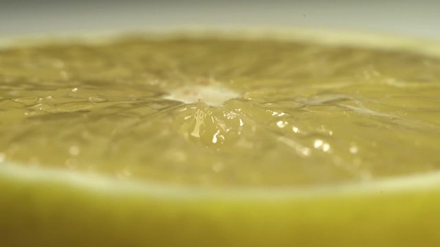Close up footage of lemon that rotates on table on white background. Fresh yellow citrus on table.