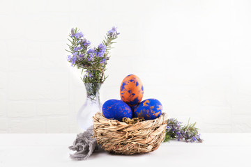 A nest with easter eggs and rosemary close up on a white background