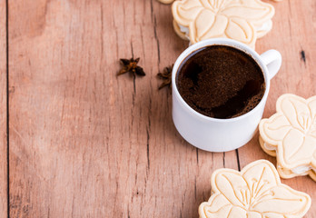 Shortbread cookies with meringue in the form of a flower, on a light wood background.