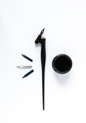 Black feather with ink well isolated on white