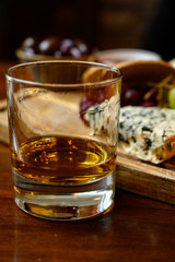 Tasting of original scottish cheese and whisky, plate with scottish cheeses and variety of Scotch in glasses