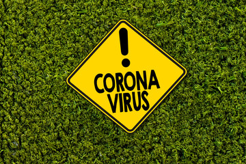 Road sign indicating coronavirus on green grass