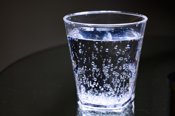 Plastic transparent glass with sparkling water with bubbles