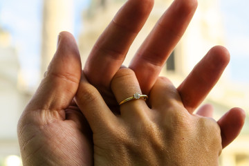 Closeup of lovers hands with an engagement ring