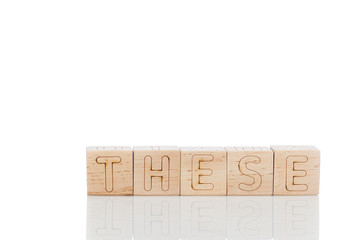 Wooden cubes with letters these on a white background
