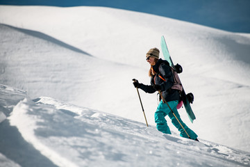 Female traveller goes up the mountain with snowboard