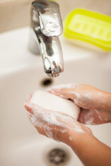 Fototapeta premium Woman washing hands with soap in bathroom. People and healthcare concept.