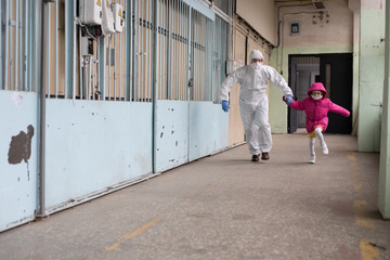A man in a protective suit evacuates people