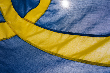 The Swedish flag, yellow and blue, blows in the wind. National day at 6th of June Summer day, the background, sunshine through the fabric. Place for text, copy space.