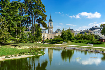 Fototapeta na wymiar green park with a view of the Beautiful baroque Festetics Castle in Keszthely Hungary reflection in the lake pond