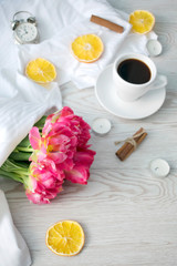 Fototapeta na wymiar Floral's spring banner. Tulips bouquet and cup of coffee on white background. Flatlay, top view. 